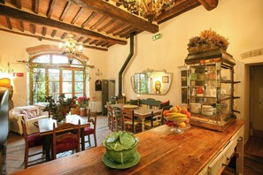 Ein gemütliches Restaurant mit Holzeinrichtung, einer grünen Tischdekoration und einer alten Vitrine.