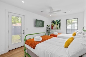 A hotel room with two beds, a ceiling fan, a TV, and artwork on the walls. - Suite Magnolia-hot Tub-pet Friendly, Mins 2 DT (Charleston)