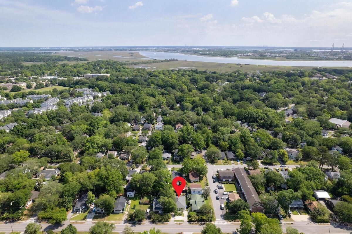 An aerial view of a residential area with houses, roads, and a river in the background.