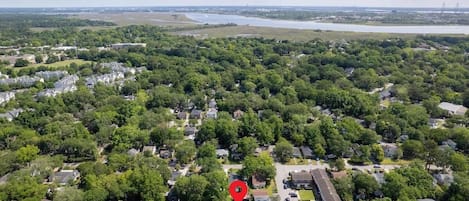 An aerial view of a residential area with houses, roads, and a river in the background.