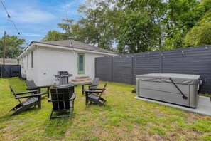 A small white house with a green door, a barbecue grill, and a tent-like structure. - Suite Magnolia-hot Tub-pet Friendly, Mins 2 DT (Charleston)