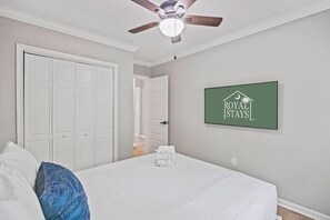 A bedroom with a bed, a ceiling fan, a door, and a sign on the wall. - Southern Shadow 8 Mins to Dtwn 5 Mins to Beach (Mount Pleasant)