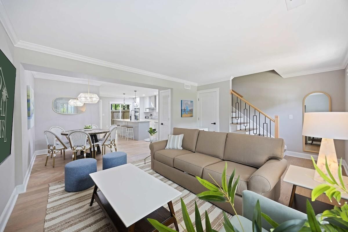A modern living room with a sofa, coffee table, and dining area.