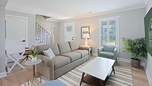 Un salon moderne avec un canapé, une table basse et une lampe.