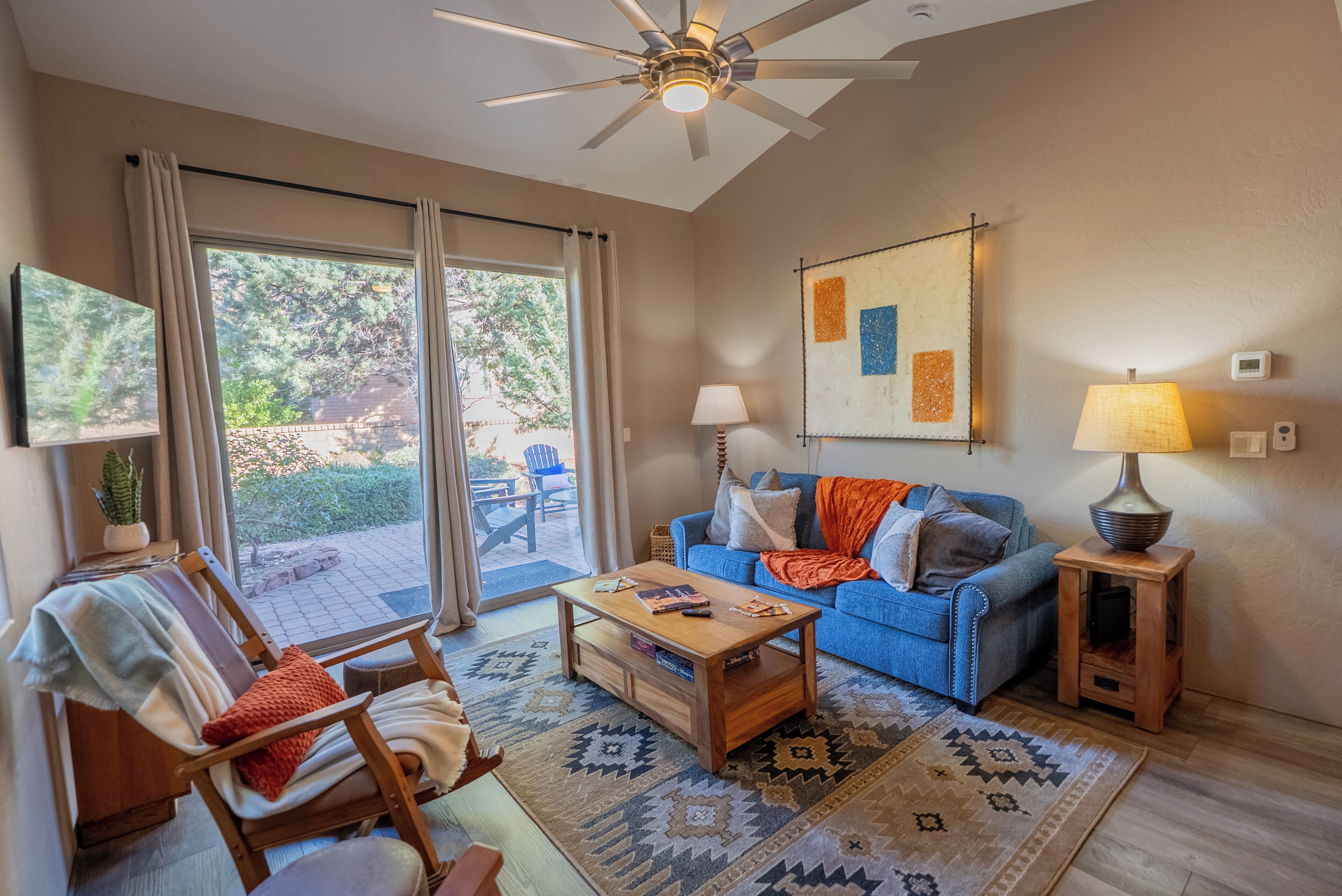 A living room with a sofa, coffee table, and a ceiling fan.