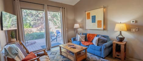 A living room with a sofa, coffee table, and a ceiling fan.