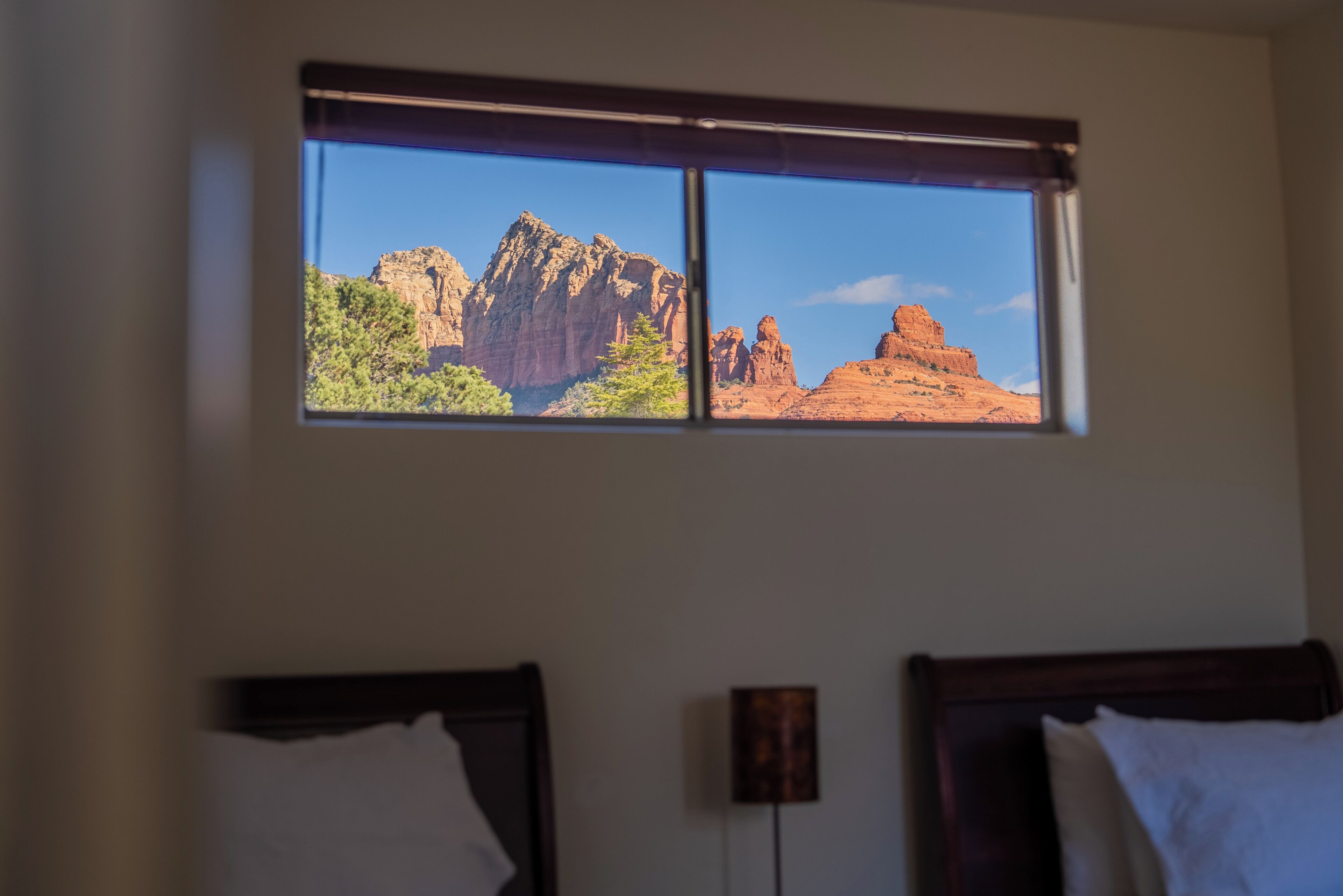 A room with a window overlooking a mountainous landscape.