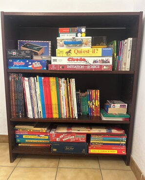 Een plank met verschillende gezelschapsspellen en boeken.