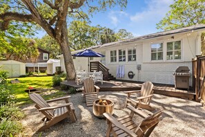 A patio with Adirondack chairs, a fire pit, and a barbecue grill. - Palms of Hart- 2 Blocks From Beach, Dog Friendly (Isle of Palms)