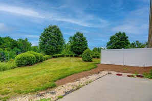 A well-maintained lawn with a white fence, a gravel path, and mature trees. - Adorable 2 Bedroom One Story Townhouse with Garage (High Point)