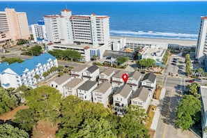 Uma área residencial costeira com edifícios altos, uma praia e um local demarcado.