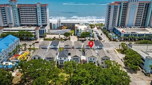 A coastal hotel with multiple buildings, a parking lot, and a view of the ocean. - The Pink Panther-ocean Side-pet Friendly (Myrtle Beach)