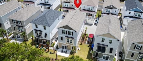 A residential area with modern two-story houses, each with a front porch and a small backyard.