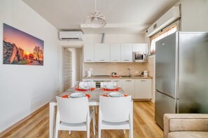 A modern kitchen with white cabinets, a stainless steel refrigerator, and a dining table set for two. - A bright apartment of approximately 70 sqm, accommodating up to two people, located on the third floor of a building with an elevator.The property is situated in Magione, about 15 km from Perugia and close to the stunning Lake Trasimeno—an ideal destin (Magione)