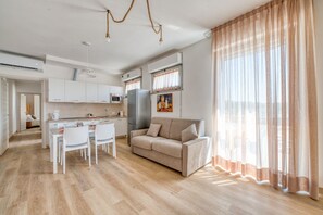 A modern living room with a sofa, dining table, and chairs. There is a kitchen area with cabinets and appliances. - A bright apartment of approximately 70 sqm, accommodating up to two people, located on the third floor of a building with an elevator.The property is situated in Magione, about 15 km from Perugia and close to the stunning Lake Trasimeno—an ideal destin (Magione)