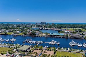 An aerial view of a marina with boats docked, a marina building, and surrounding greenery. - Myrtle Dunes- Across From Beach, Pet Friendly (Myrtle Beach)