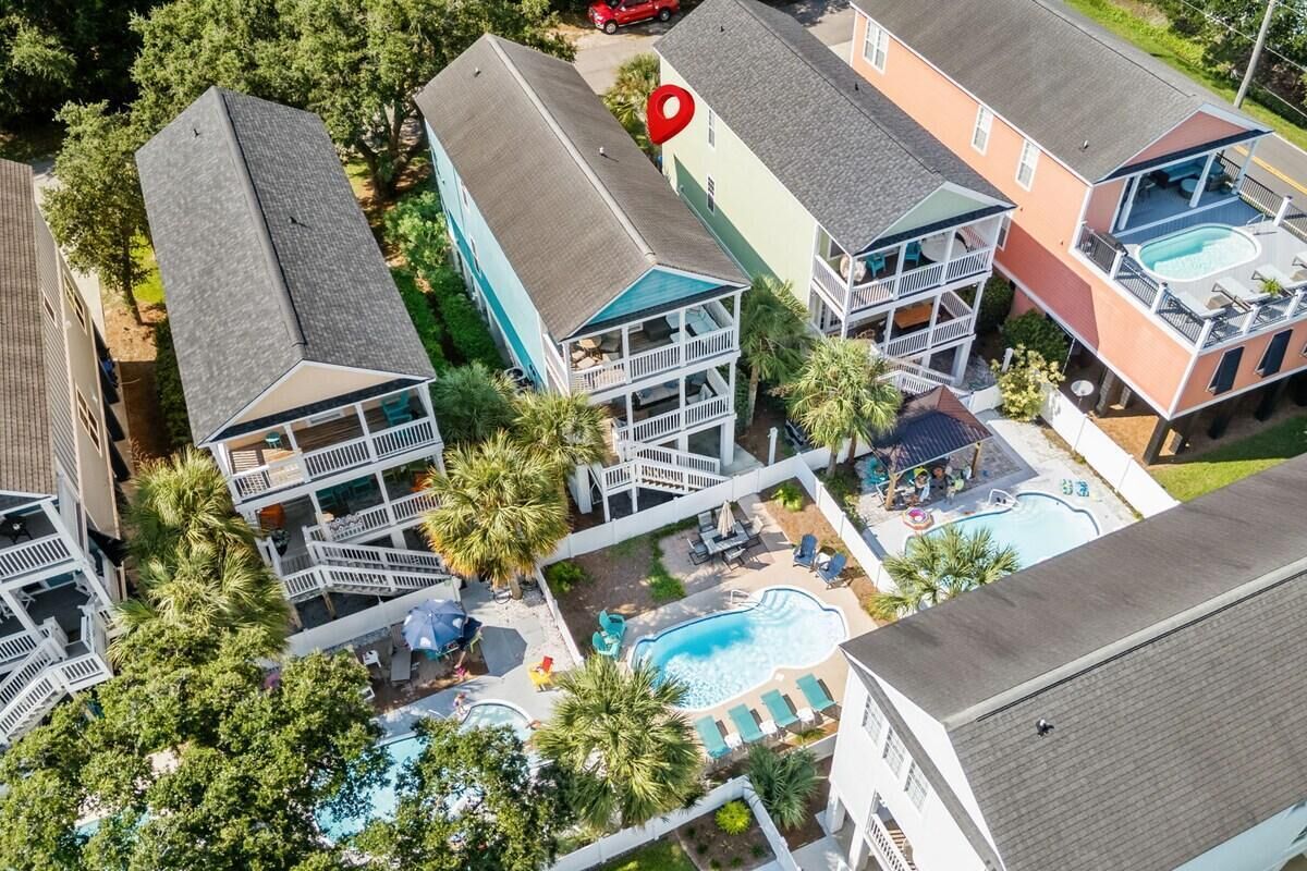 A residential complex with multiple two-story buildings, a swimming pool, and a red location marker.