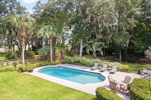 A swimming pool with lounge chairs and a wooden deck, surrounded by lush greenery and trees. - Boview Hall- Pool, Hot Tub-15 Mins to Kiawah (Johns Island)