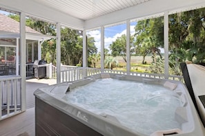 A hot tub in a covered outdoor area with a view of trees and a grassy field. - Boview Hall- Pool, Hot Tub-15 Mins to Kiawah (Johns Island)