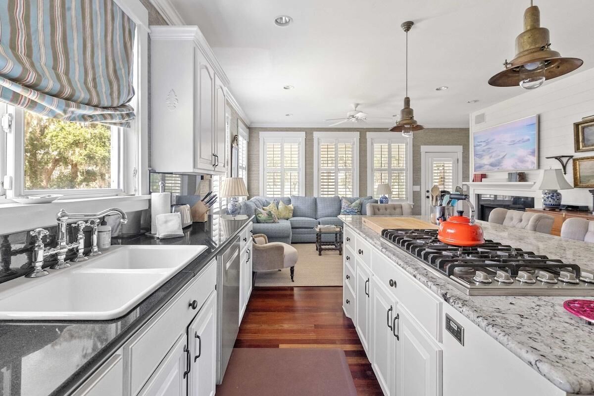 A spacious kitchen with a central island, a dining area, and a living room.