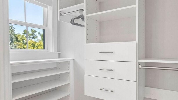 A walk-in closet with open shelving, a window, and a metal rod for hanging clothes. - Sincerely Shem Iii- 7 min to Beach and Dtwn CHS (Mount Pleasant)