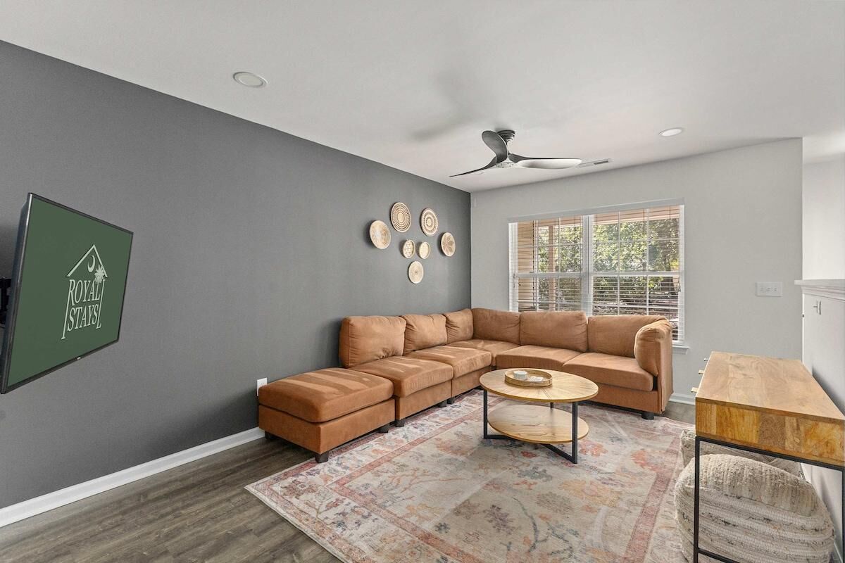 A modern living room with a sectional sofa, a coffee table, and a rug.