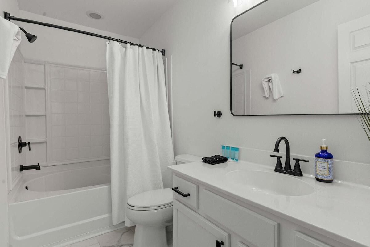 Un bagno moderno con vasca, water e lavandino.