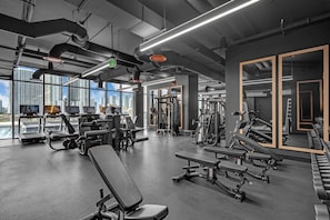 A modern gym with exercise equipment, large windows, and a city view. - E11EVEN Studio · Bay Views + Rooftop Day Club Pool (Miami)