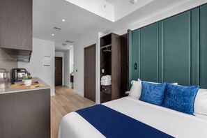A hotel room with a bed, a desk with a coffee machine, a wardrobe, and a bathroom visible in the background. - E11EVEN Studio · Bay Views + Rooftop Day Club Pool (Miami)