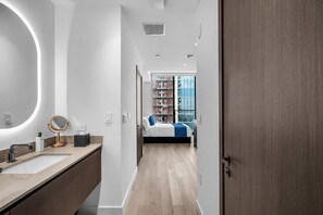 Une salle de bain moderne avec un miroir rond, un lavabo et un meuble-lavabo.