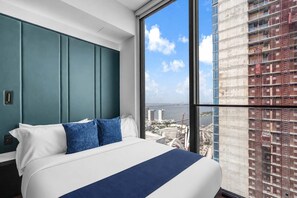 A modern hotel room with a large bed, a view of a cityscape, and a large window. - E11EVEN Studio · Bay Views + Rooftop Day Club Pool (Miami)