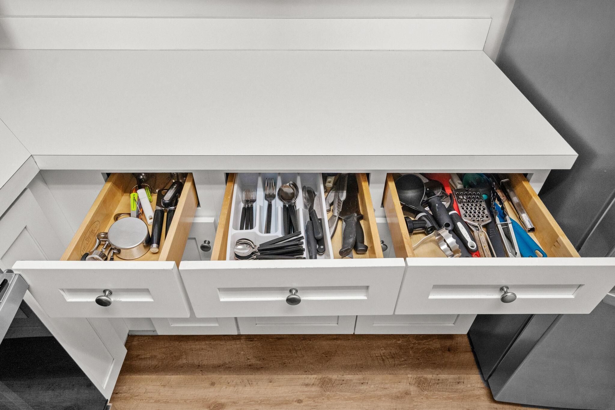 Un cajón de cocina con utensilios y herramientas.