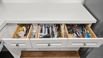 Un cajón de cocina con utensilios y herramientas.