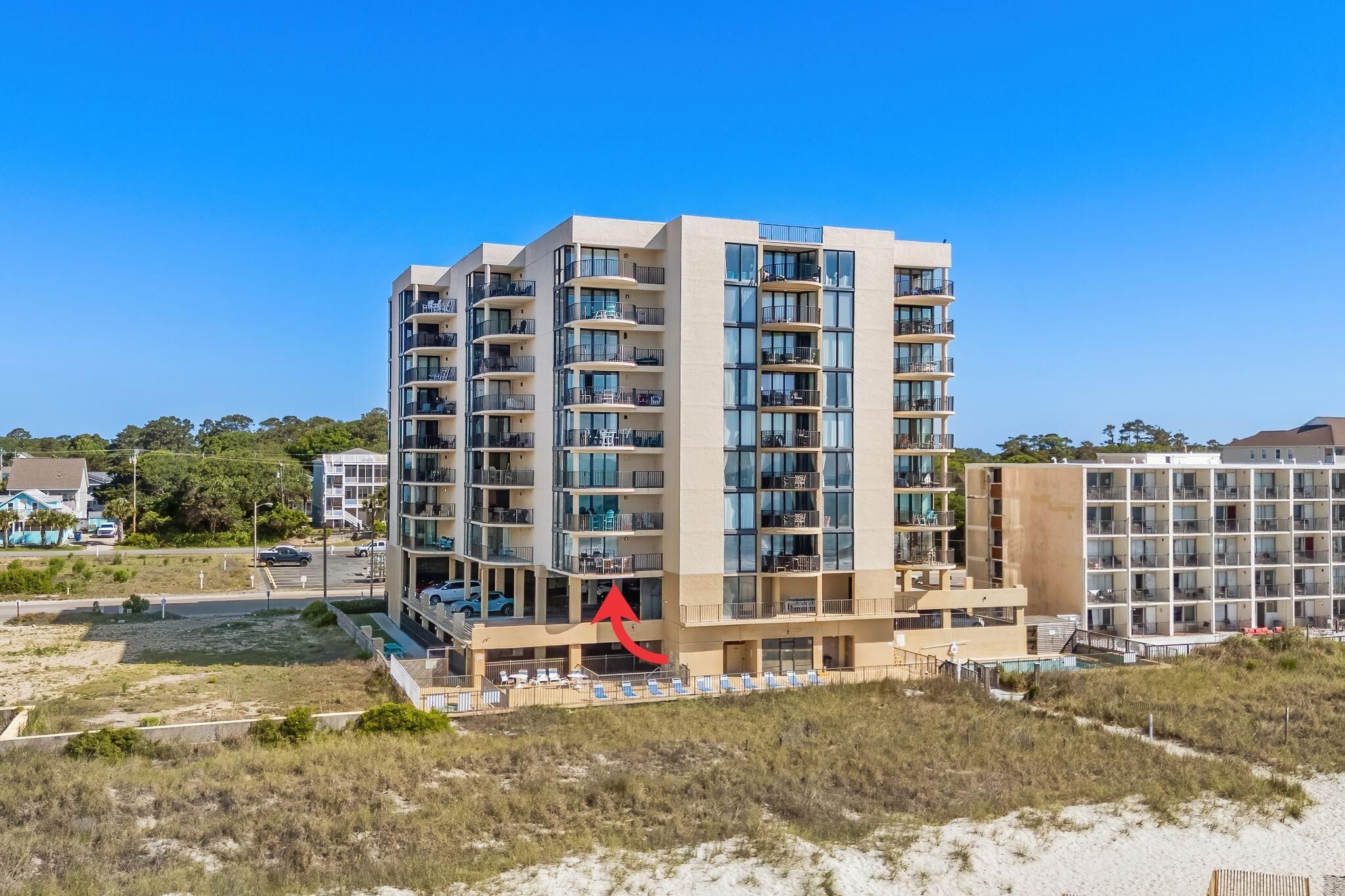 Un hôtel à plusieurs étages doté de balcons, d’un espace piscine et offrant une vue sur la plage.