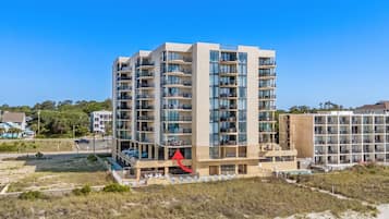 Un hôtel à plusieurs étages doté de balcons, d’un espace piscine et offrant une vue sur la plage.