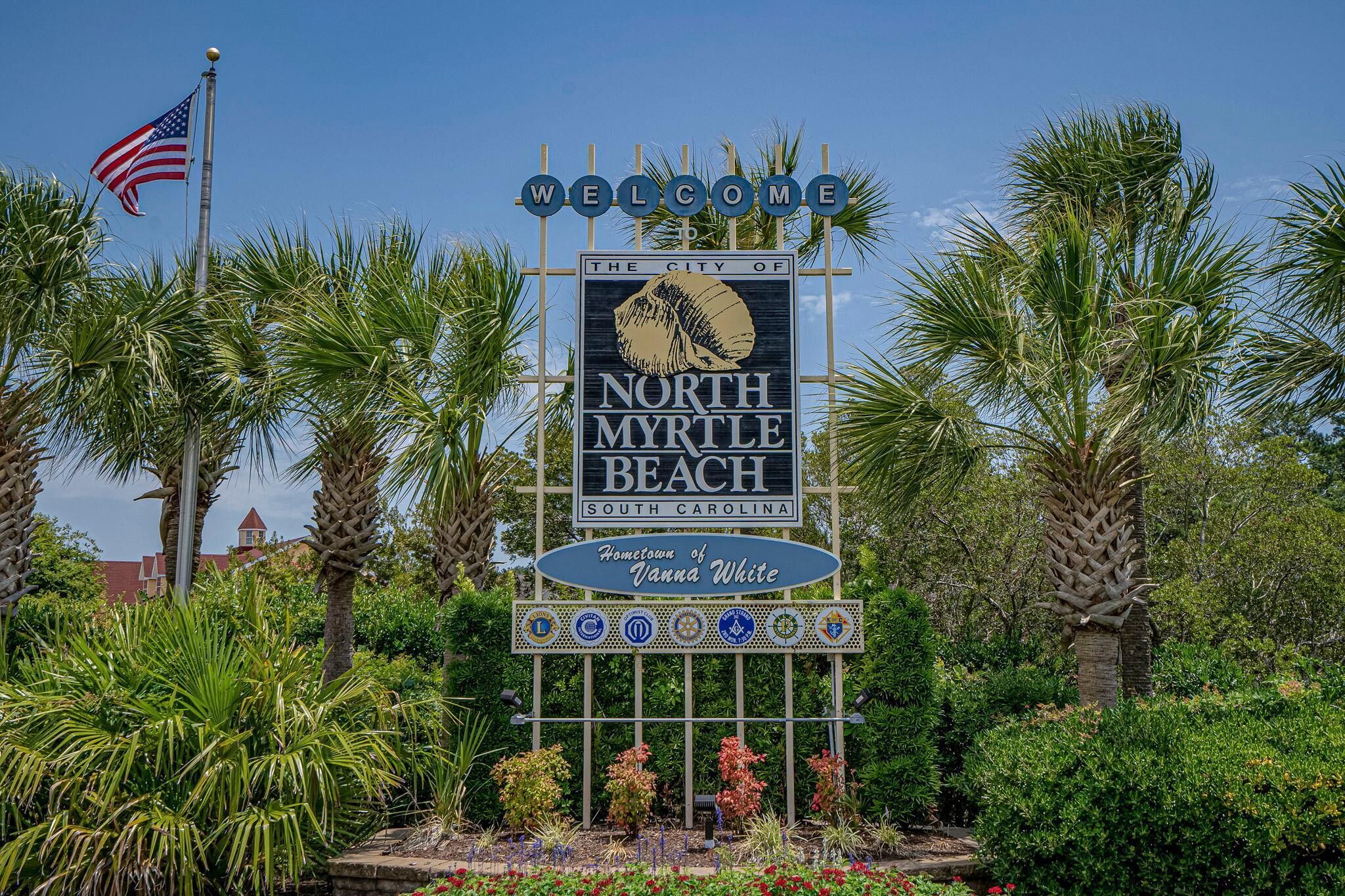 A welcome sign for North Myrtle Beach, SC, with a palm tree and American flag.