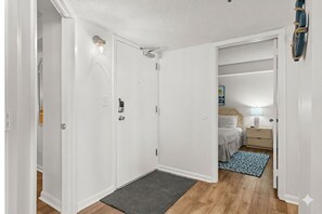 Un dormitorio con cama, mesita de noche, lámpara y una alfombra.