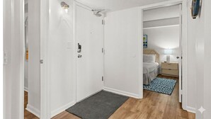 A bedroom with a bed, bedside table, lamp, and a rug. - Beachfront Breeze @ Sea Castle North Myrtle Beach (North Myrtle Beach)