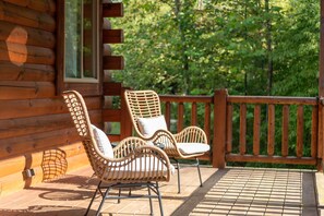 A wooden deck with two wicker chairs and a metal railing. - Majestic Lodge | Theater & Game Rm, Hocking Hills (Creola)