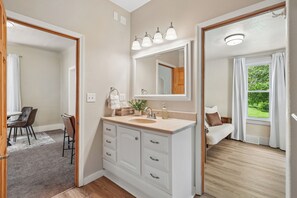 A modern bathroom with a large mirror, a sink, and a shower area.