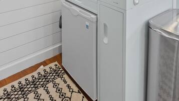 Een kleine keuken met een fornuis, spoelbak en een spiegel boven het aanrecht.