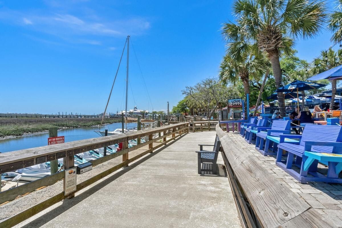 A wooden pier with blue seating and a sign for 'Love Shak'.