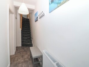 A staircase leading to a landing with a bench and a radiator on the wall. - Mona Lodge (Llandudno)