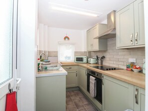 A compact kitchen with a microwave, toaster, and oven. - Mona Lodge (Llandudno)