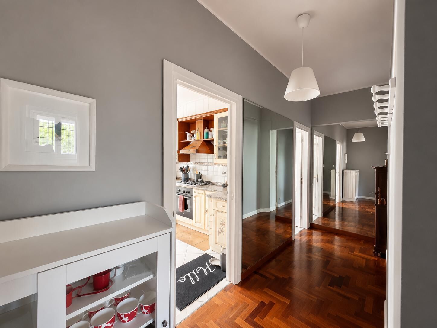 Une cuisine moderne avec des meubles en bois, une cuisinière et un coin repas comprenant une table et des chaises blanches.