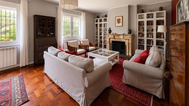 A living room with a fireplace, bookshelves, and a sofa.