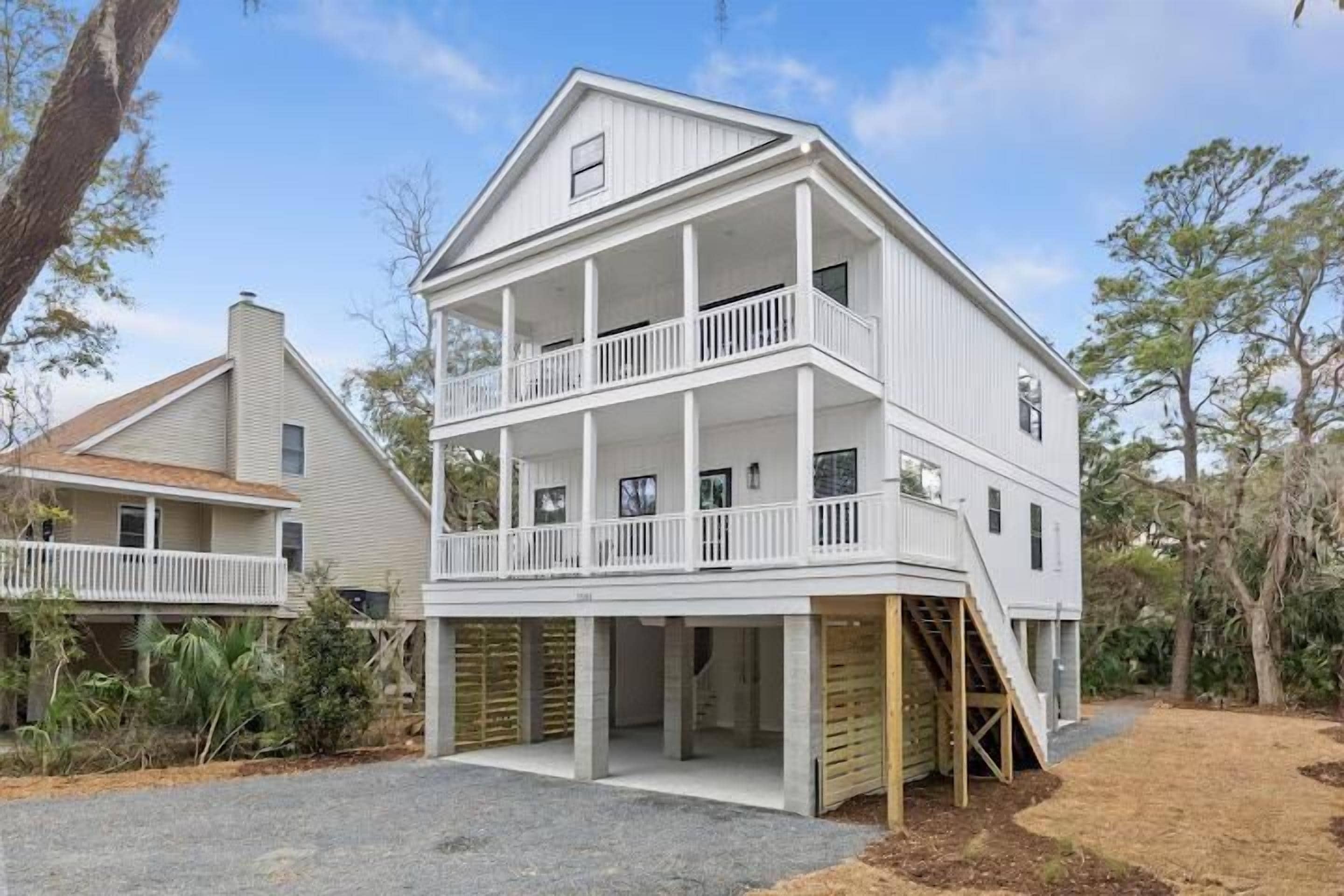 A two-story house with a balcony on the upper floor, a covered front porch, and a staircase leading to the entrance.