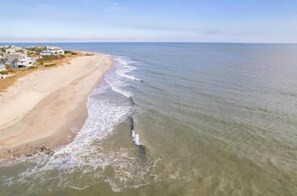 Vista aérea de una playa con casas a lo largo de la orilla.