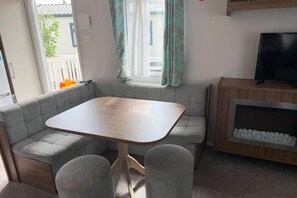 Un espacio habitable compacto con un sofá, una pequeña mesa y un televisor.