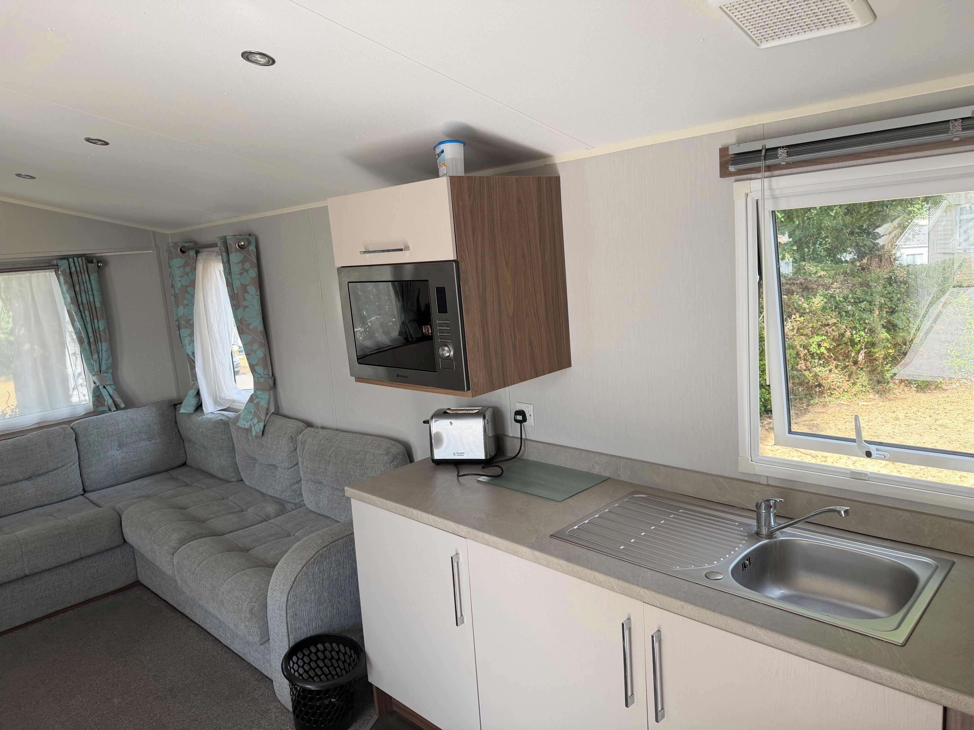 Una kitchenette compacta con microondas, tostadora y pileta.